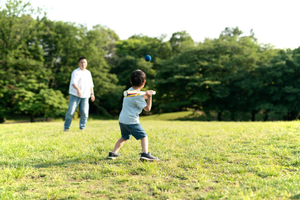 幼少期の子ども芝生で野球をしている様子